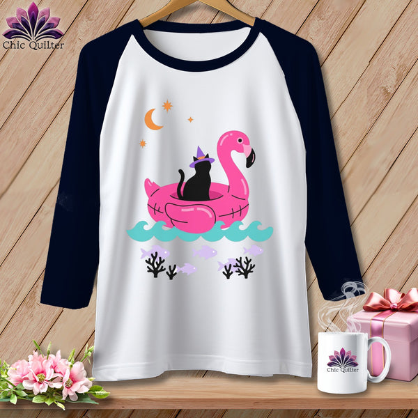 T-shirt with black cat on flamingo float, moon, stars, and fish graphic.
