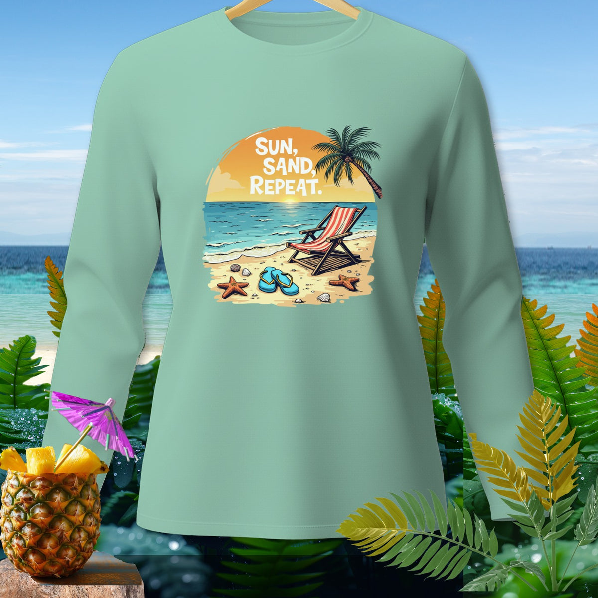 Mint green long sleeve shirt with beach graphic and text "SUN, SAND, REPEAT."