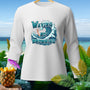 White long-sleeved shirt with a graphic reading "WAVING NOT DROWNING" on a beach background.