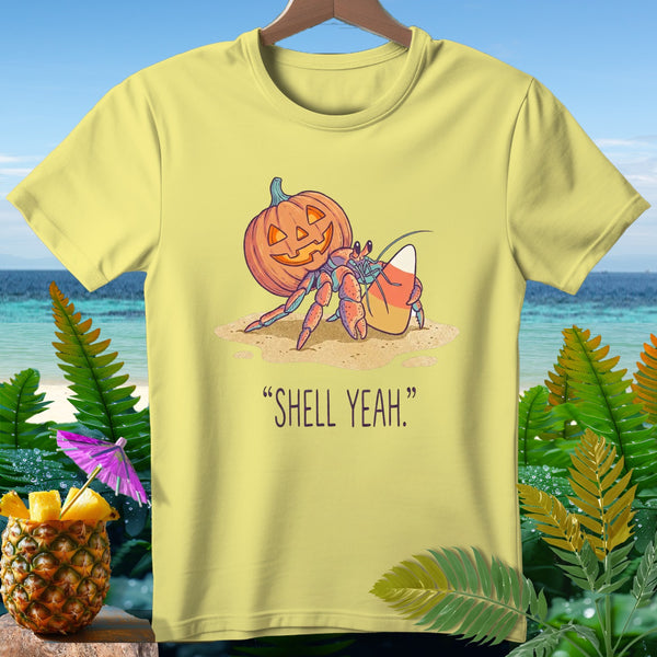 Hermit crab with pumpkin shell and candy corn on sand, text "SHELL YEAH."