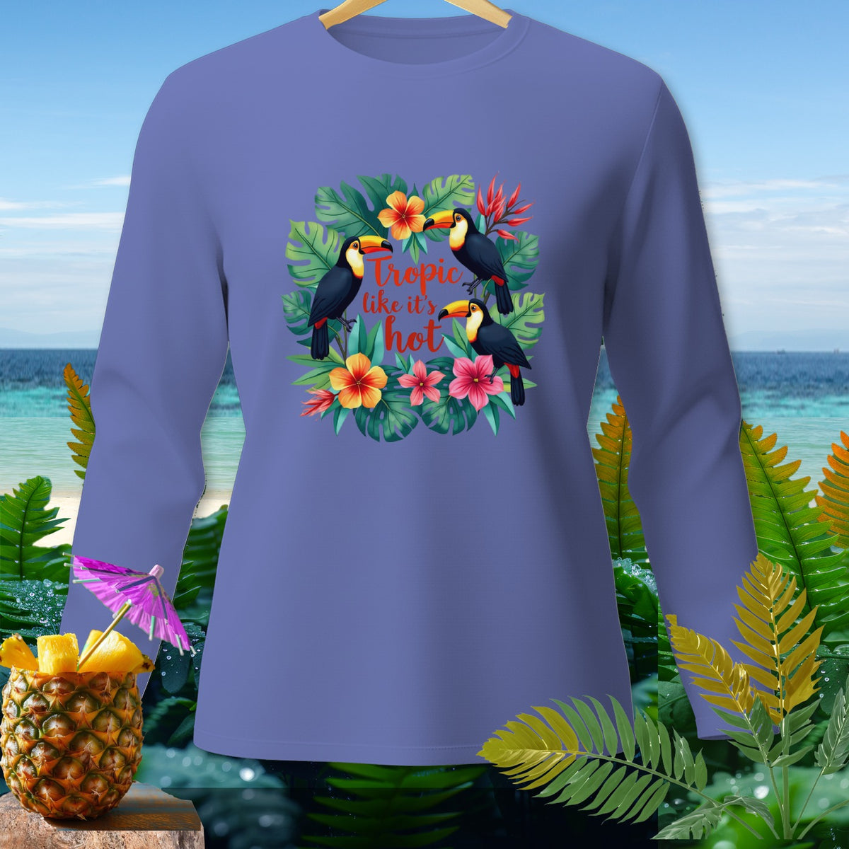 Purple long-sleeve shirt with toucans and tropical flowers, reading "Tropic like it's hot."
