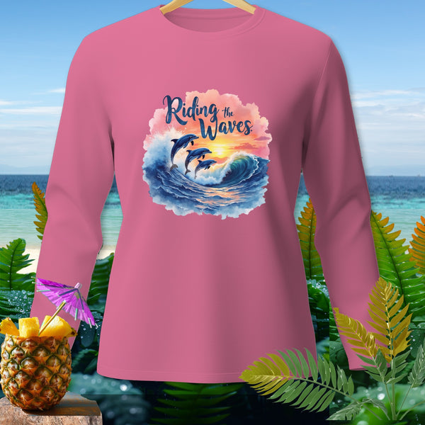 Pink long-sleeve shirt with dolphins riding waves and the text "Riding the Waves."