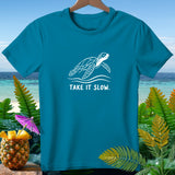 Teal t-shirt with a white sea turtle design and text 
