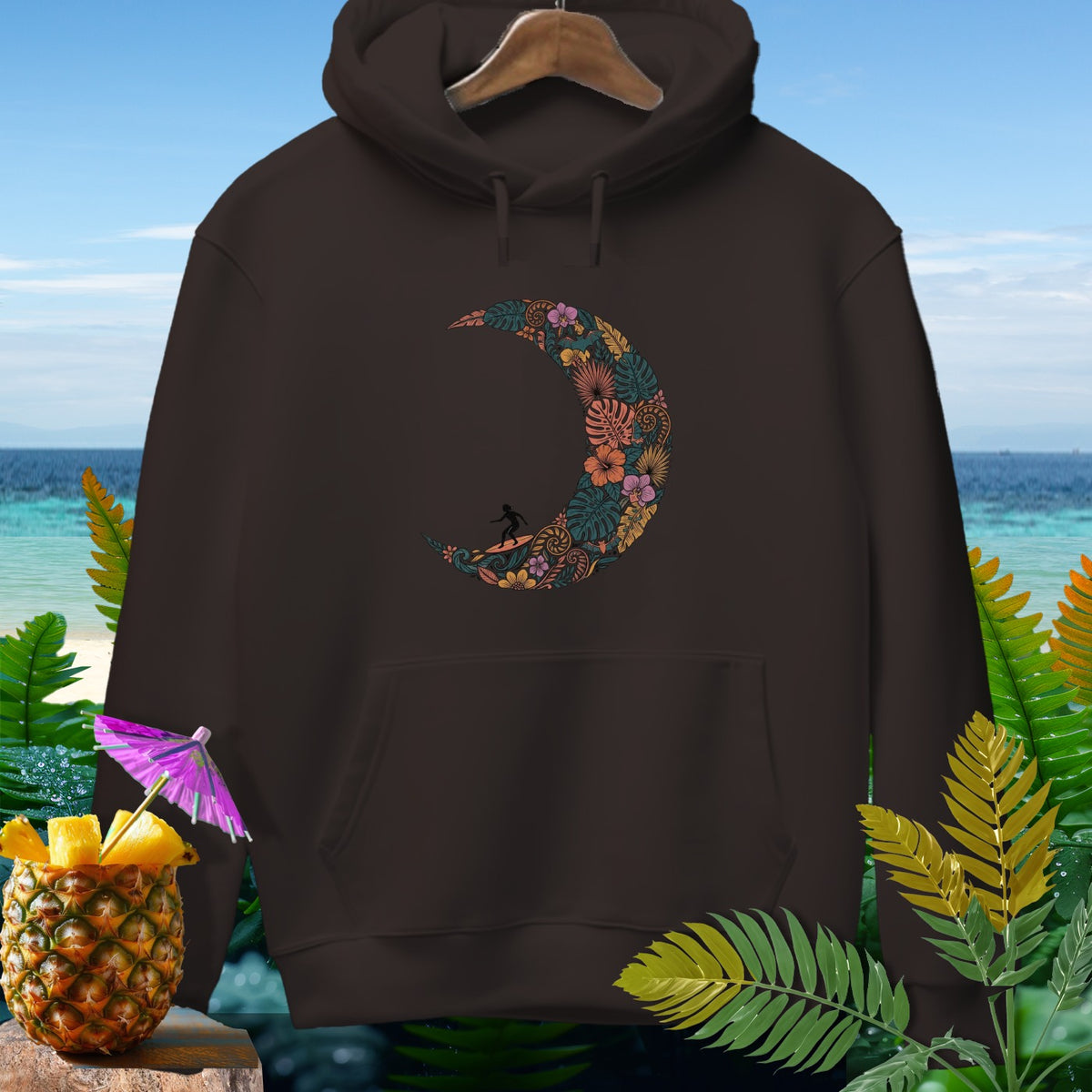 Brown hoodie with a crescent moon floral design featuring a surfer.