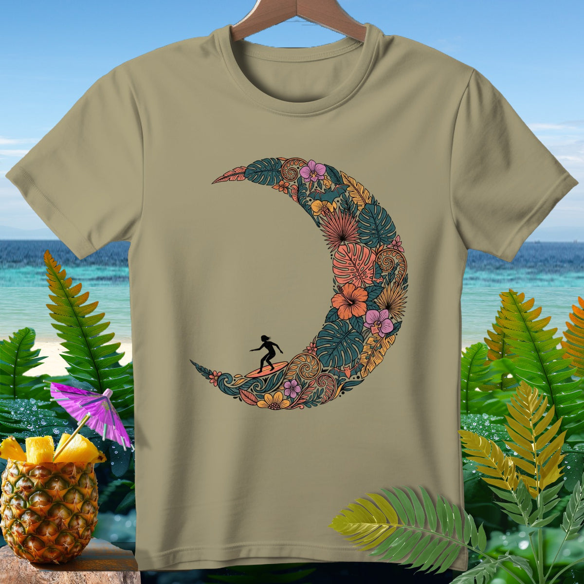 T-shirt with a crescent moon design filled with tropical flowers and a surfer.