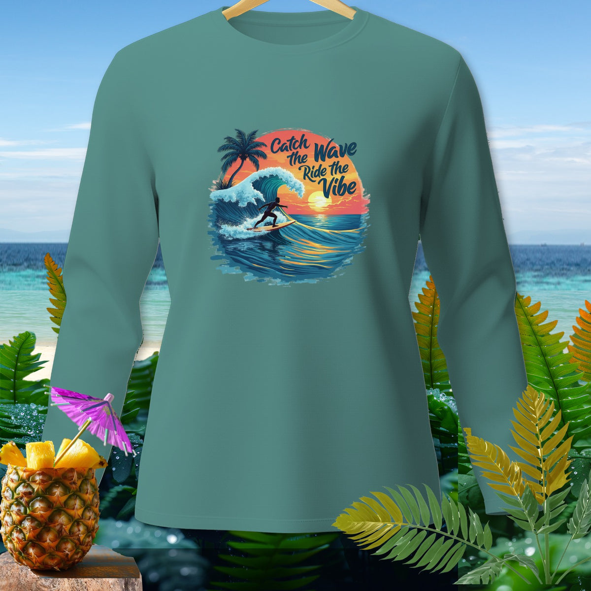 Teal long-sleeve shirt with graphic: surfer riding wave, text "Catch the Wave Ride the Vibe".