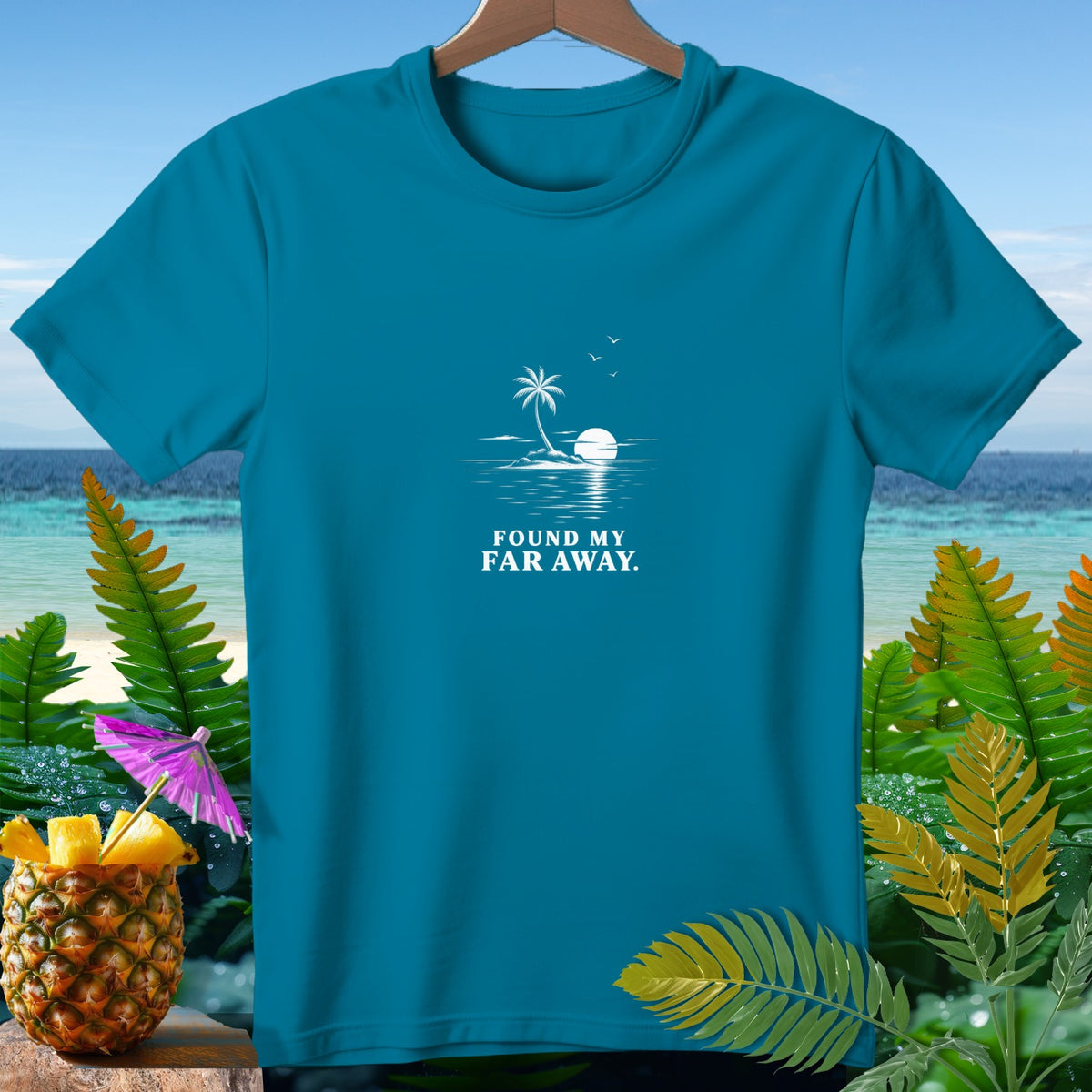 Teal t-shirt with white graphic of island, palm tree, and "FOUND MY FAR AWAY." text.