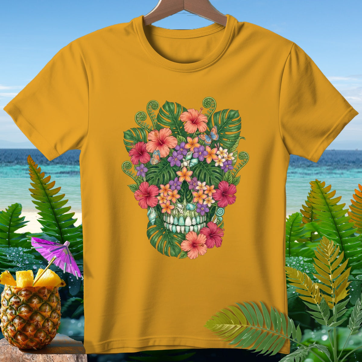 Yellow t-shirt featuring a floral skull design with butterflies against a beach backdrop.