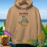 Tan hoodie featuring a skeleton in a Hawaiian shirt holding a surfboard and pumpkin bucket with text.