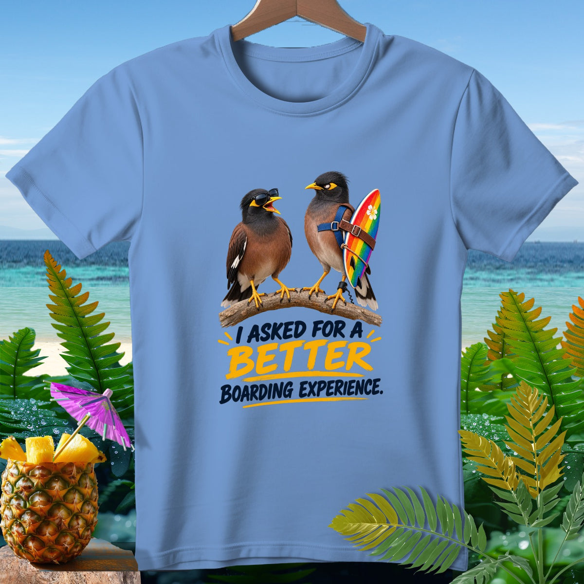 Two birds wearing sunglasses and a rainbow surfboard are printed on a light blue t-shirt.