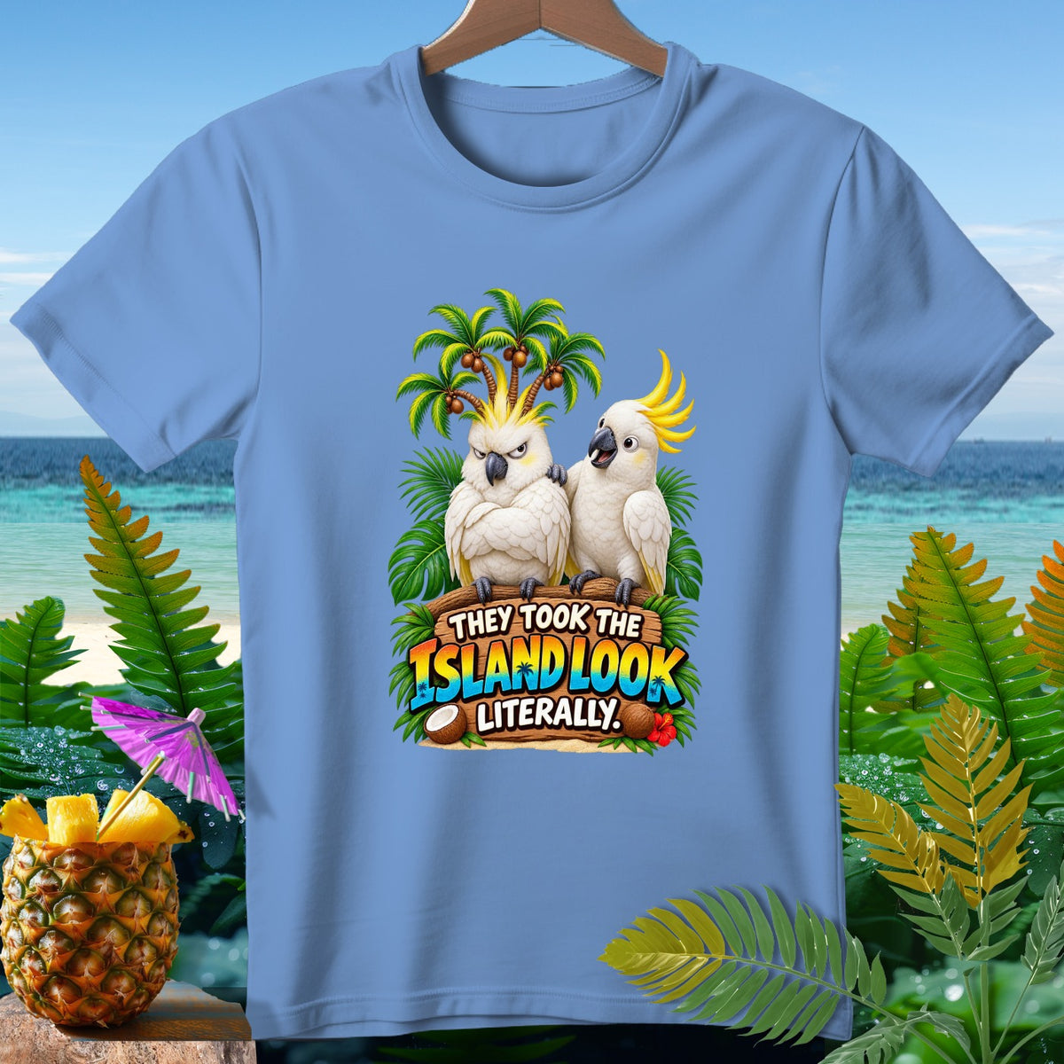 Light blue t-shirt with two cockatoos and text "THEY TOOK THE ISLAND LOOK LITERALLY".