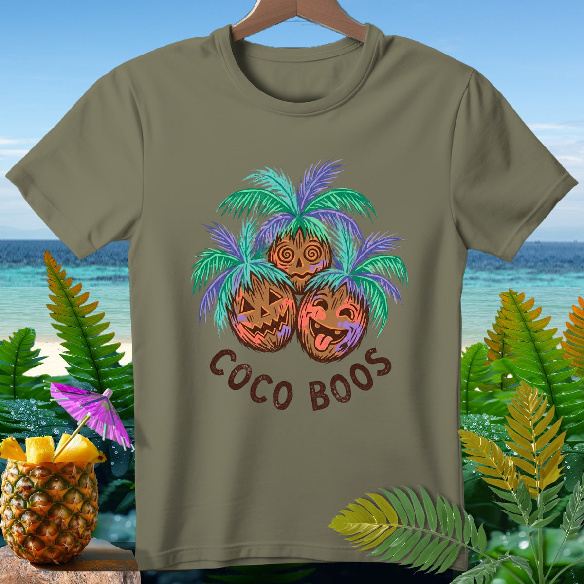 Olive t-shirt with "Coco Boos" text and three jack-o'-lantern coconuts with palm leaves.