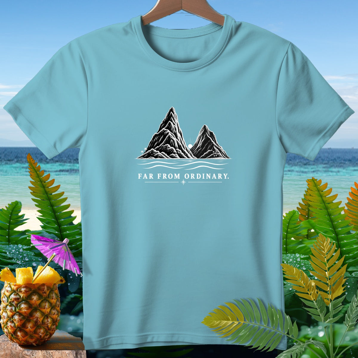 Light blue t-shirt with mountain and ocean graphic and "Far From Ordinary" text.