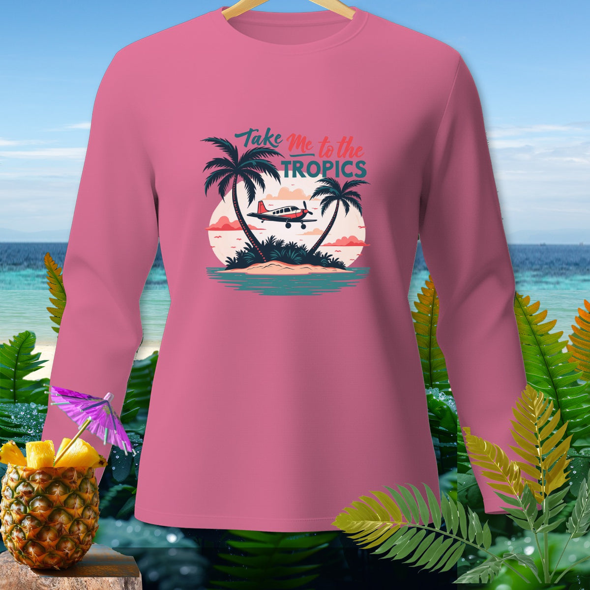Pink long-sleeve shirt with a tropical graphic and text "Take Me to the TROPICS."