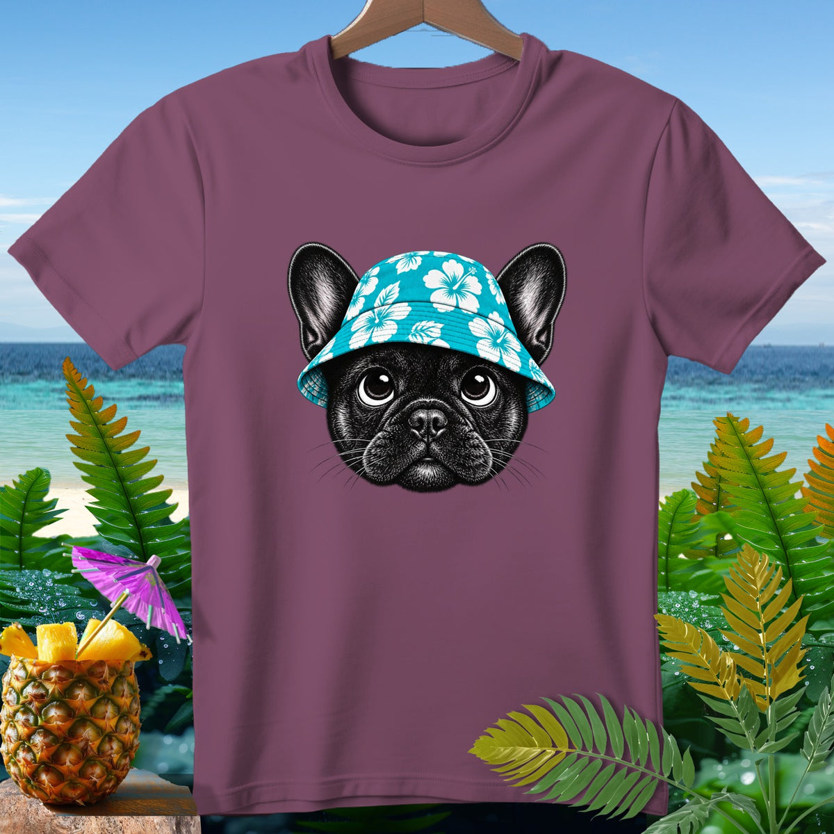 French bulldog wearing a blue hibiscus bucket hat on a plum t-shirt.