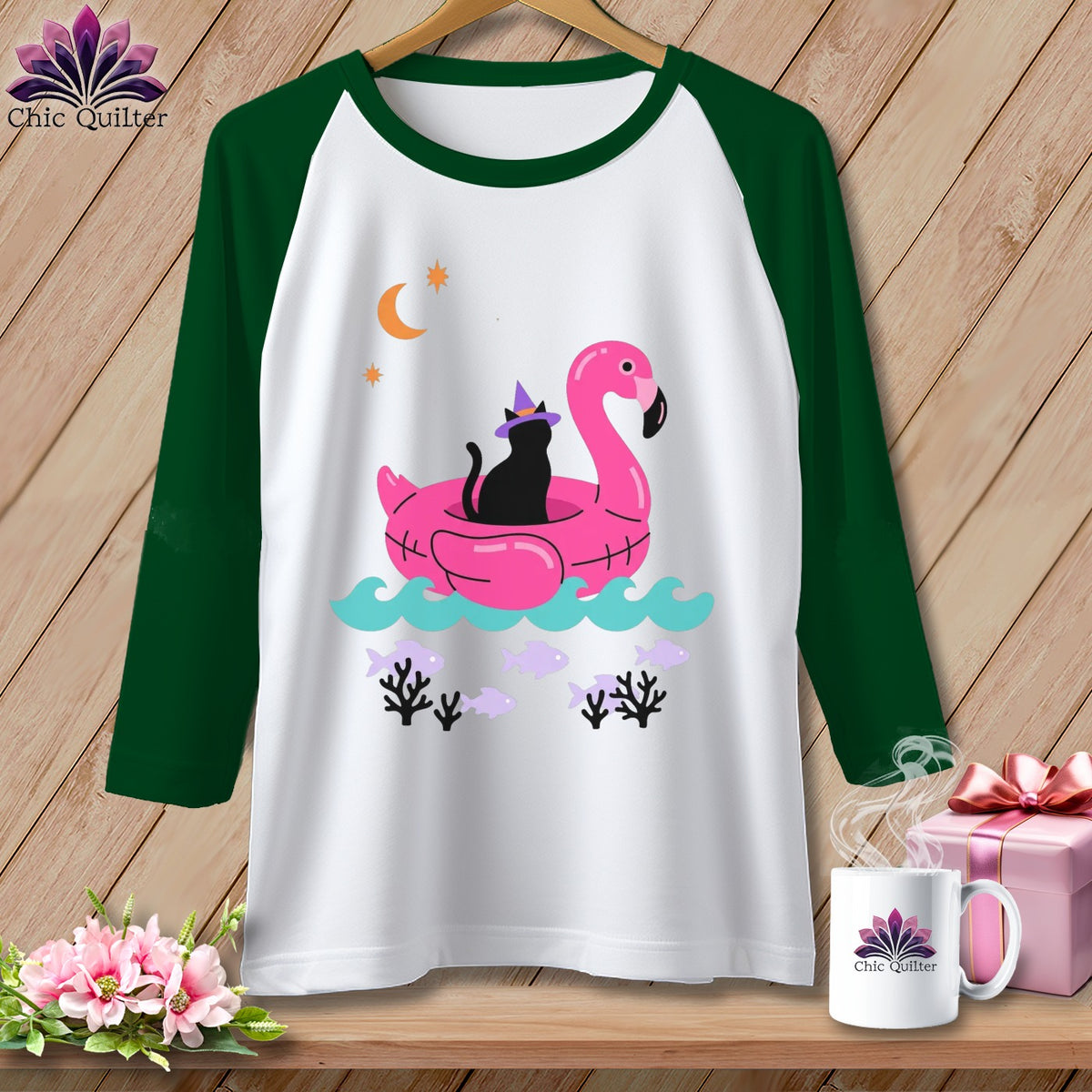 Green raglan sleeve shirt with black cat on pink flamingo float graphic.