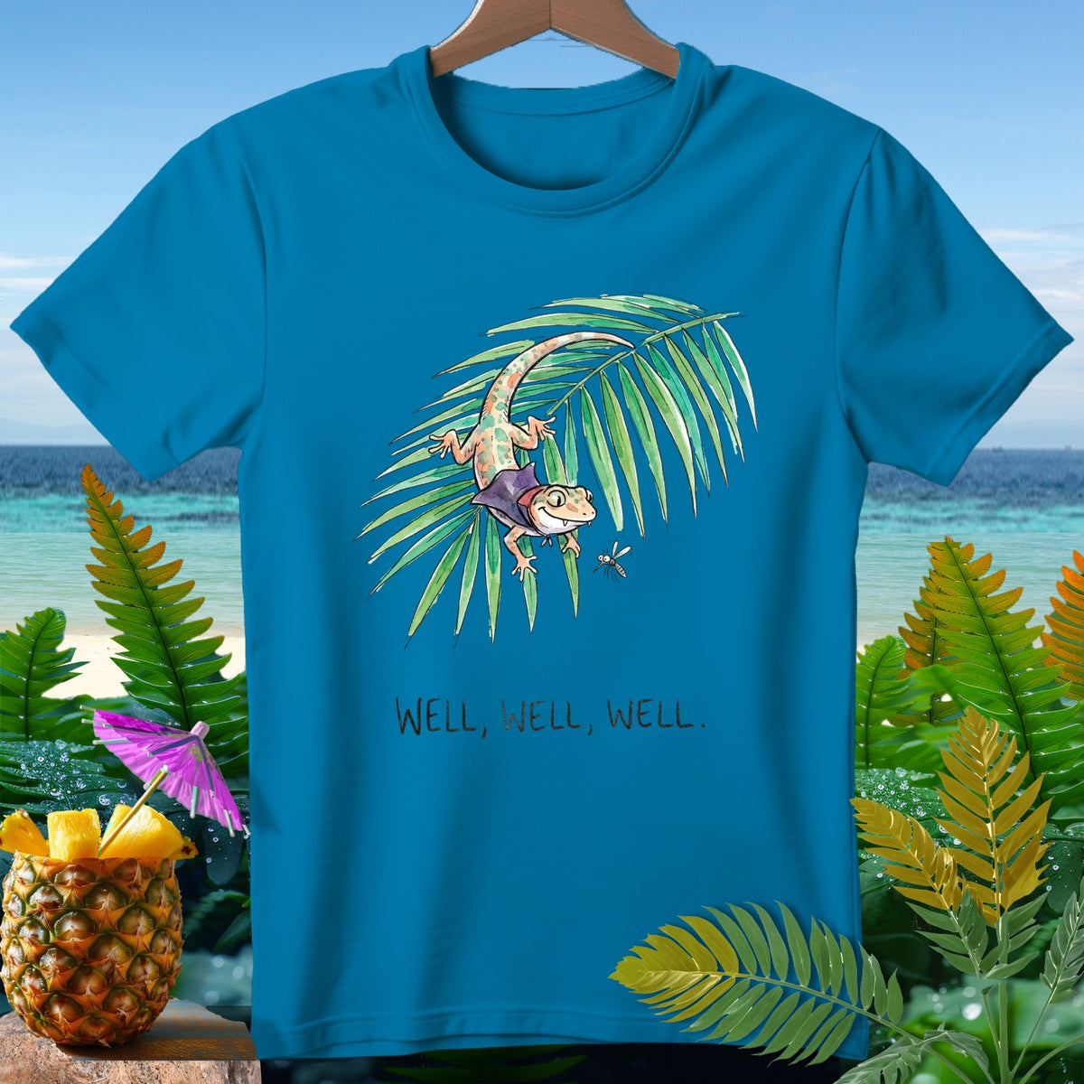 Blue t-shirt with gecko on palm frond and text "WELL, WELL, WELL."
