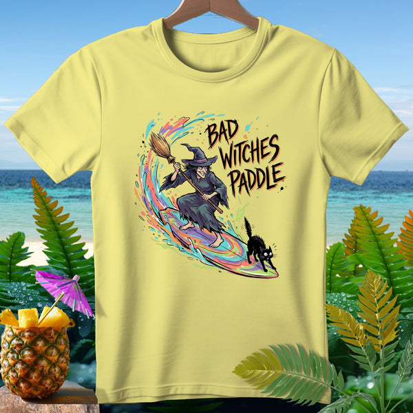 Yellow t-shirt with witch and black cat surfing, text says "Bad Witches Paddle."