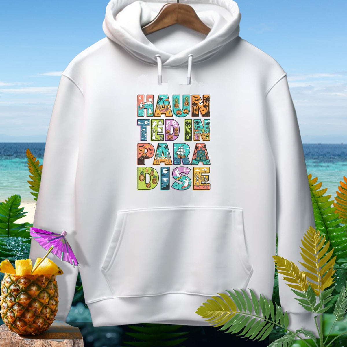 White hoodie with "Haunted in Paradise" text featuring Halloween and tropical elements.