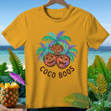 Yellow t-shirt with three coconuts dressed as pumpkins and palm trees, text 