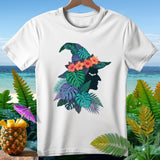 White t-shirt featuring a witch hat silhouette adorned with tropical leaves and flowers.