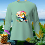 Long-sleeve t-shirt with a toucan, sunset, and tropical foliage graphic.