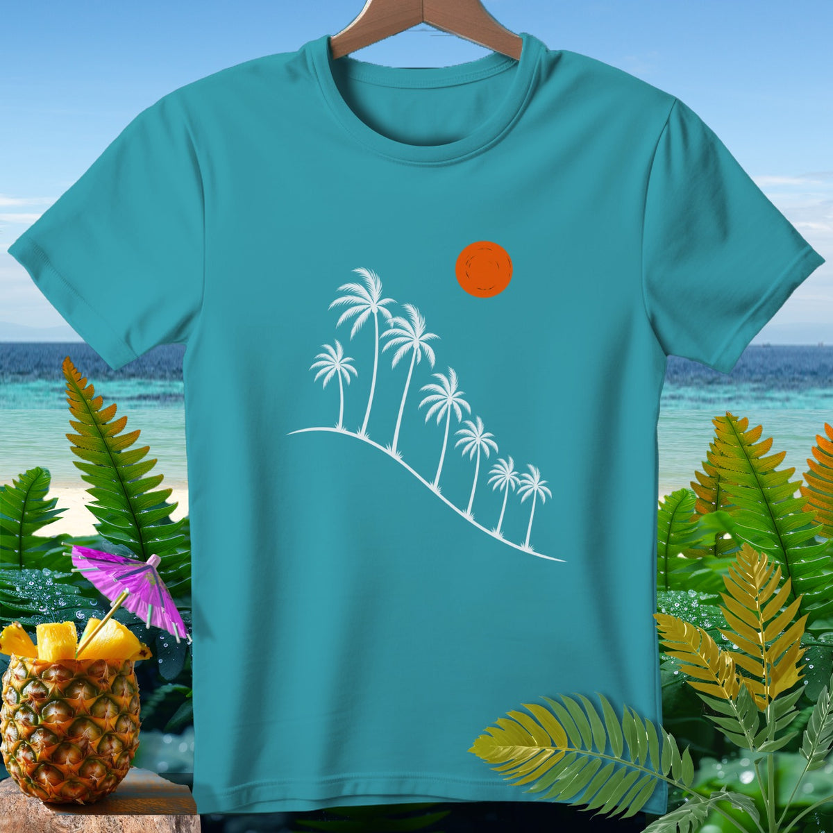 Teal t-shirt with white palm trees, orange sun, and tropical foliage.