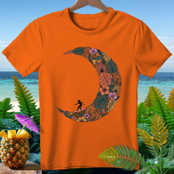 Orange t-shirt with a crescent moon graphic filled with tropical leaves and flowers, featuring a surfer.