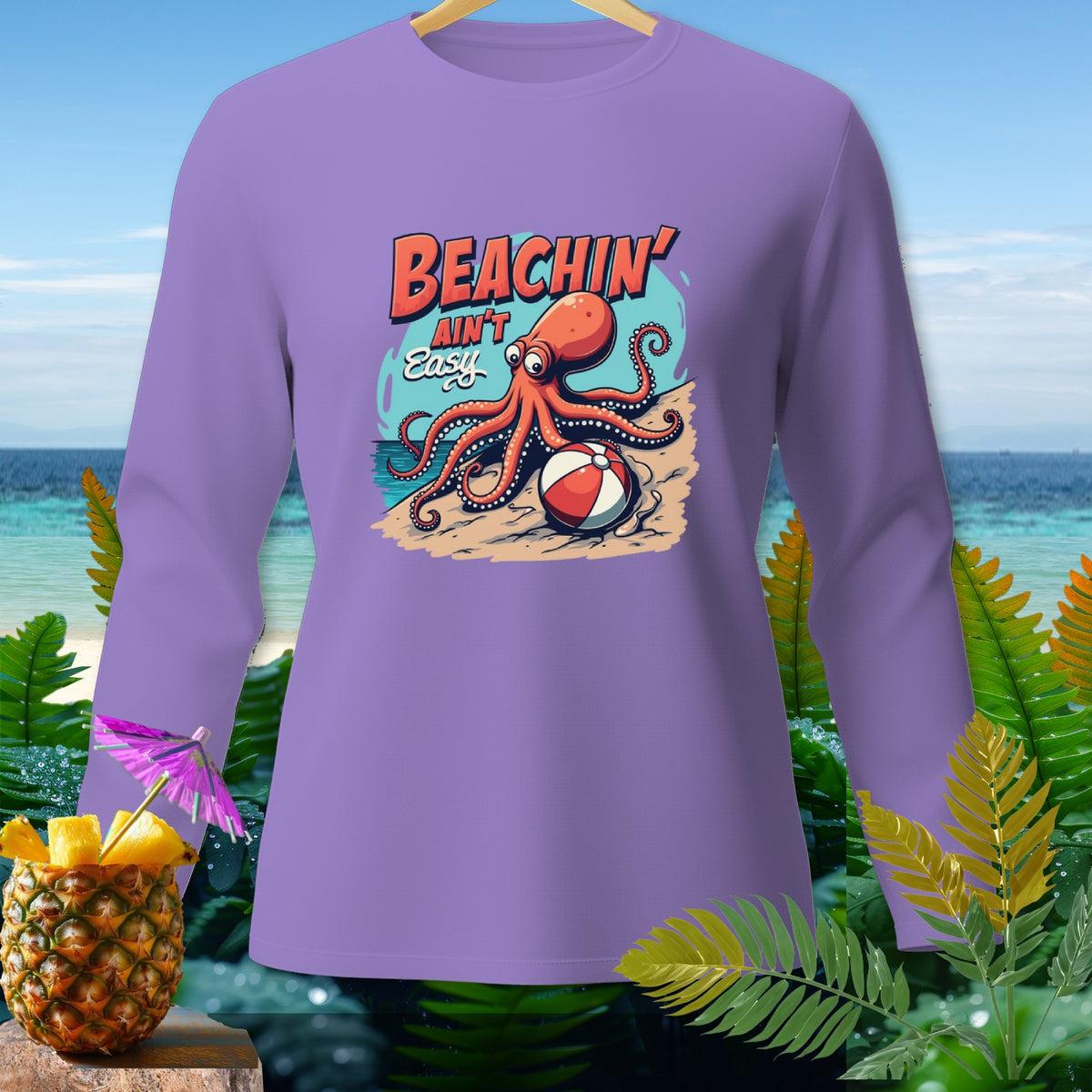 Purple long-sleeve shirt with cartoon octopus and beach scene graphic.