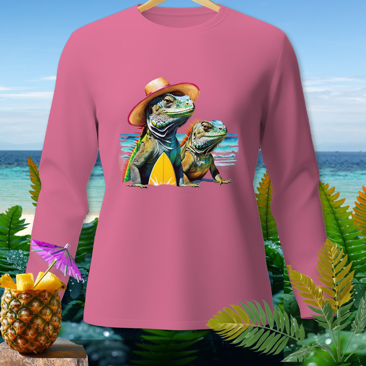 Pink long-sleeved shirt with cartoon iguanas and surfboards on a beach background.
