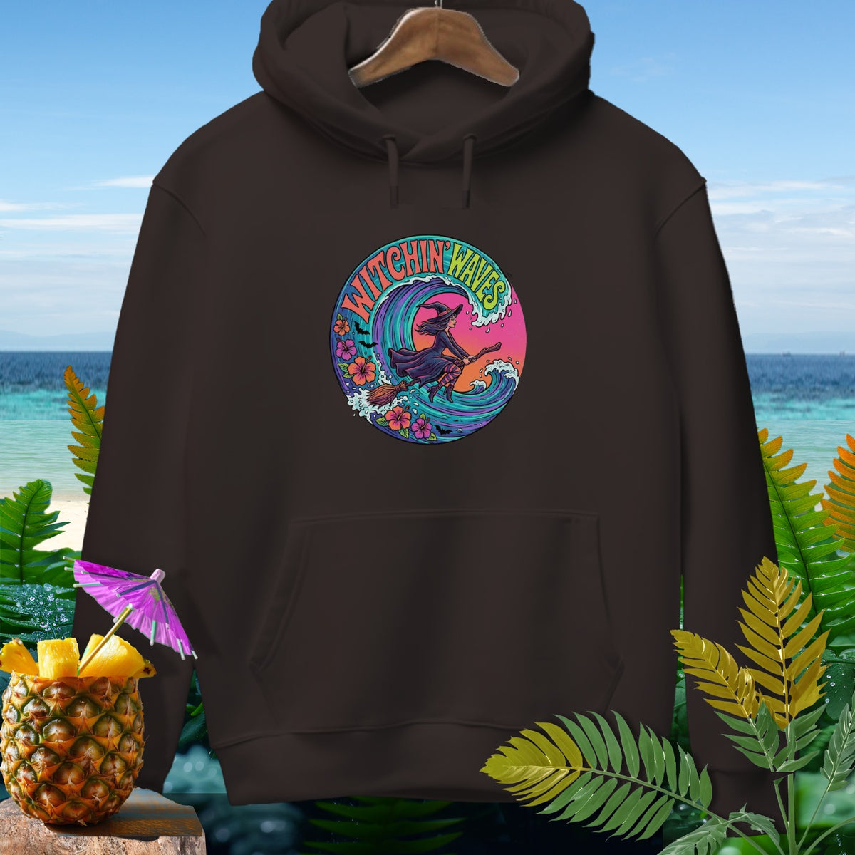Brown hoodie with circular graphic of a witch riding a broomstick on a wave