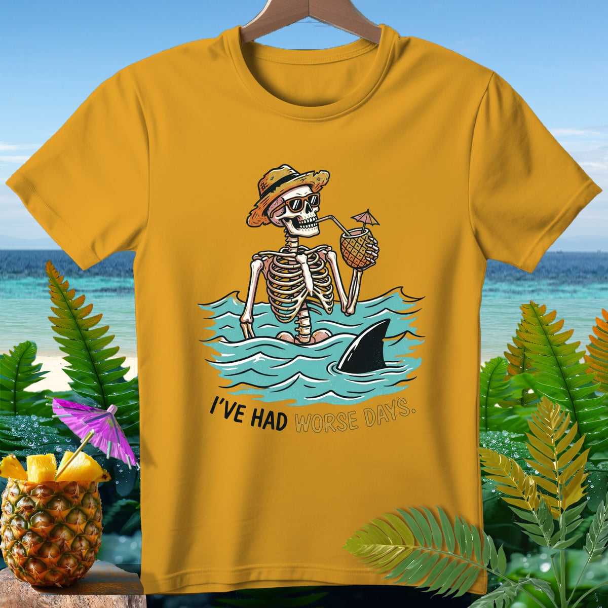 Skeleton in ocean drinking from pineapple with shark fin and text "I'VE HAD WORSE DAYS."