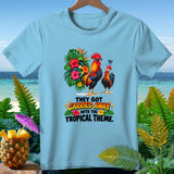 Light blue t-shirt with two roosters, tropical flowers, and the text 