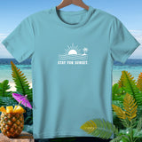 Light blue t-shirt with white graphic of sun, waves, palm tree, and 