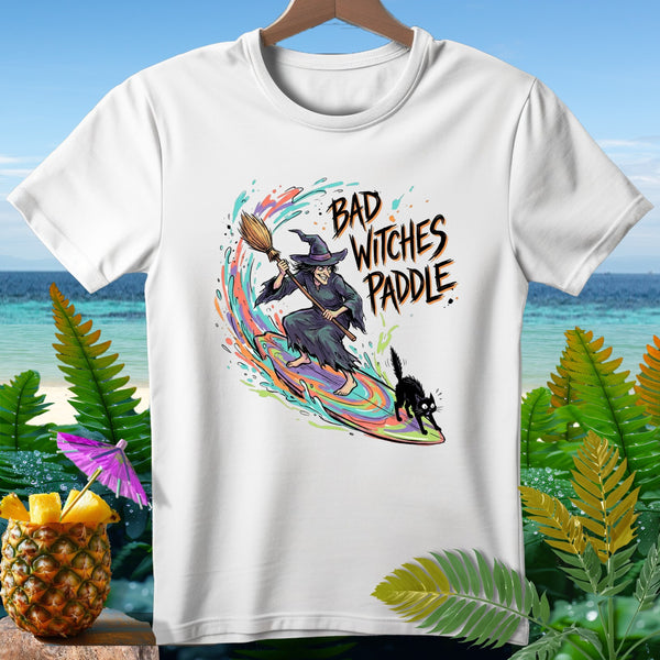 T-shirt with witch surfing on a broom, black cat, and "Bad Witches Paddle" text.