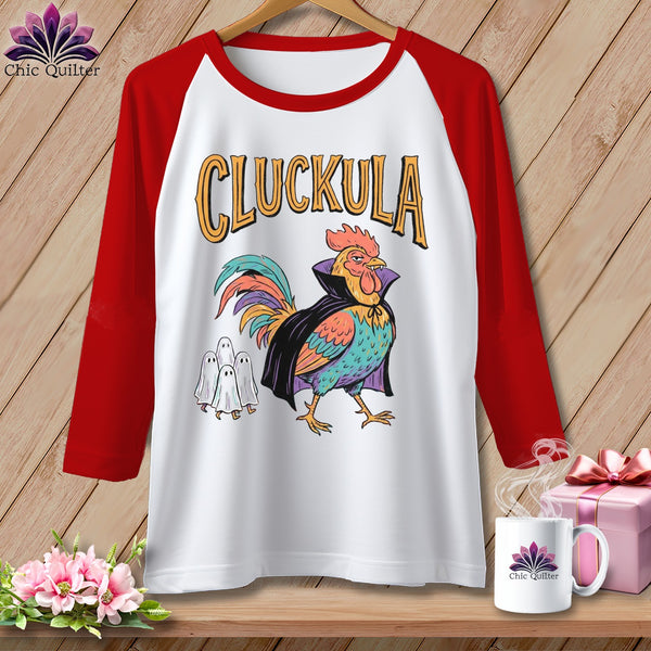 Raglan shirt with "CLUCKULA" text and cartoon rooster in vampire costume.