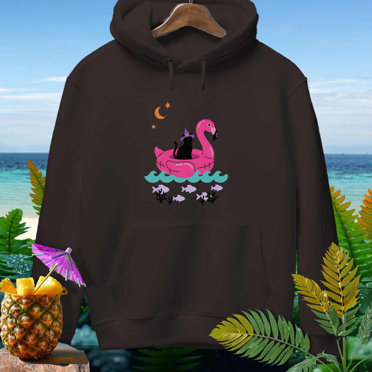Brown hooded sweatshirt featuring a graphic of a black cat in a witch hat floating in a pink flamingo tube.
