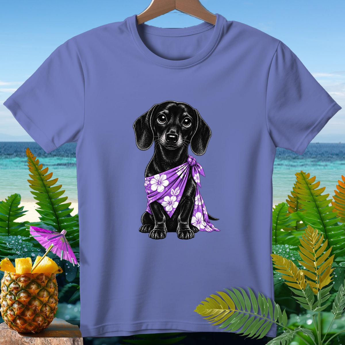 Black dachshund wearing a purple floral bandana on a purple t-shirt.