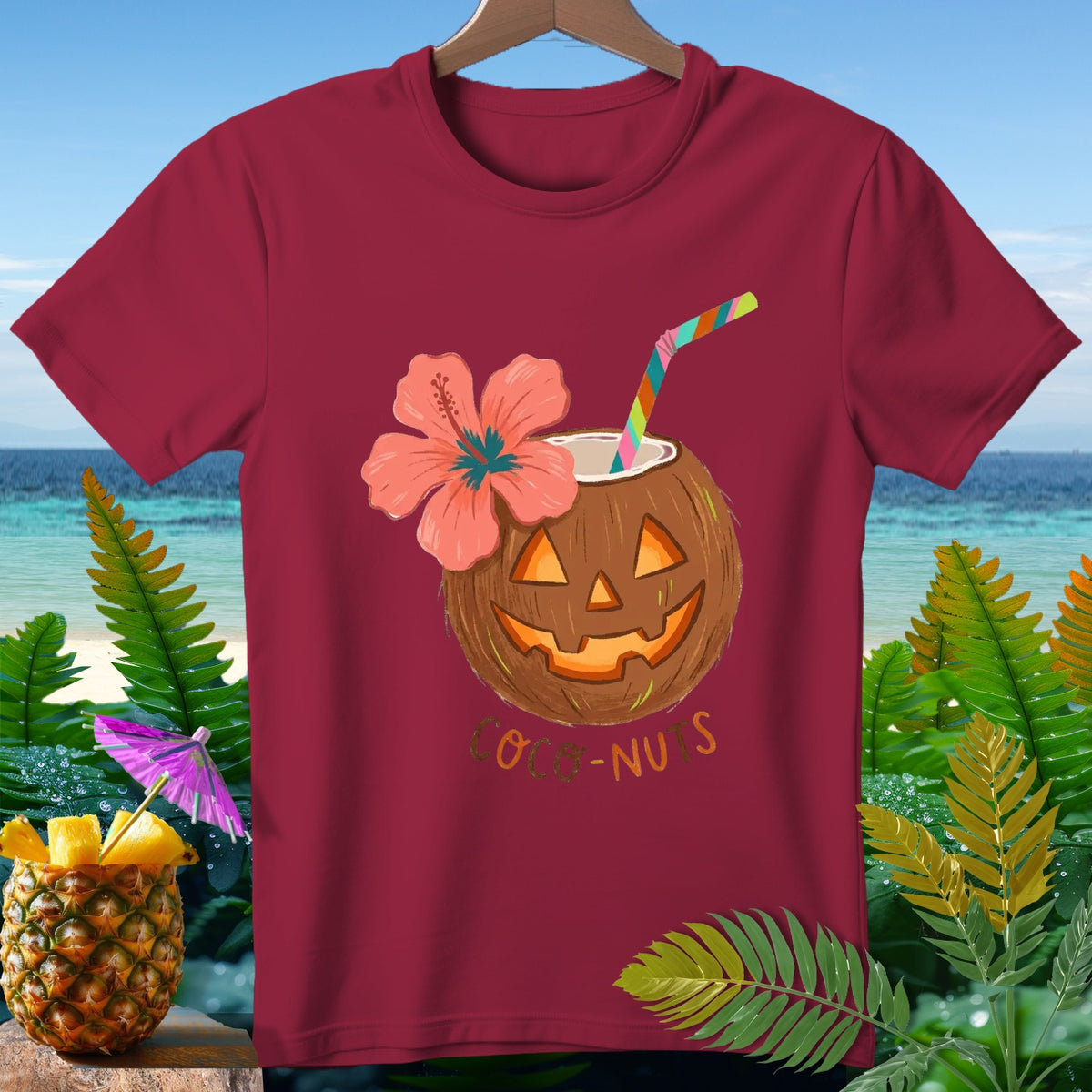 Maroon t-shirt with jack-o'-lantern coconut, hibiscus flower, and text "COCO-NUTS".