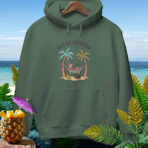 Green hoodie with "Hex on Vacation" graphic of witch in hammock, palm trees, and cat.