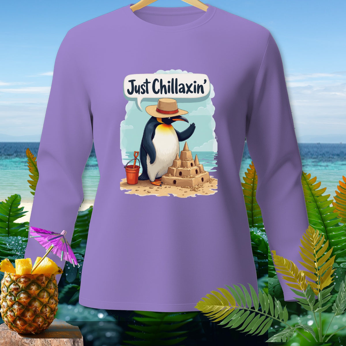Purple long-sleeve shirt with a penguin building a sandcastle, saying "Just Chillaxin'".